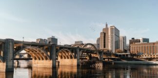 Minnesota AG Warns VGW, Zula & Fortune Coins to Halt Sweepstakes Casinos Bridge and city skyline reflected on a river in Minnesota.