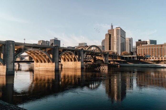 Bridge and city skyline reflected on a river in Minnesota.