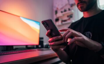 Mohegan Digital Launches Online Sportsbook in Pennsylvania Man in black shirt holding a smartphone.
