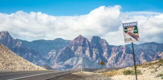 Nevada desert highway with scenic byway sign and mountains in the background