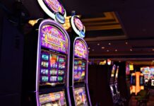 Row of illuminated slot machines inside a casino.