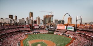 Busch Stadium in St. Louis filled with fans during a baseball game at sunset
