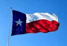 Texas state flag waving against a clear blue sky
