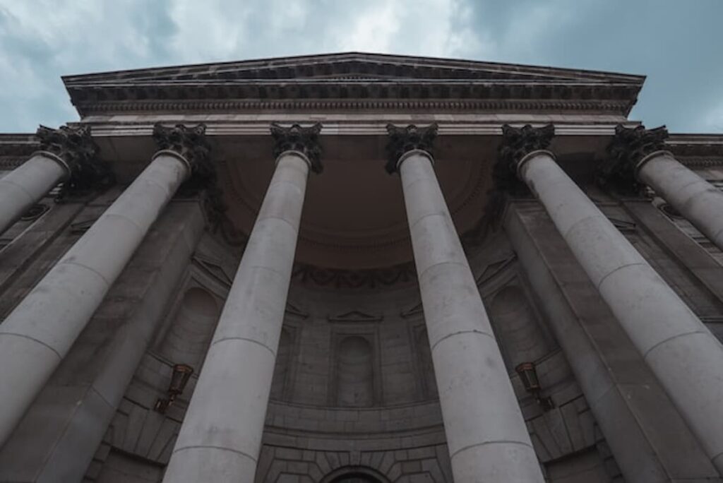 A large stone courthouse with tall columns under a blue sky