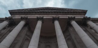 CFTC Details How it Reviews Sports Event Contracts in Response to Senators’ Questions A large stone courthouse with tall columns under a blue sky