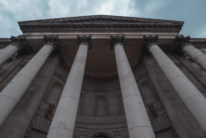 A large stone courthouse with tall columns under a blue sky