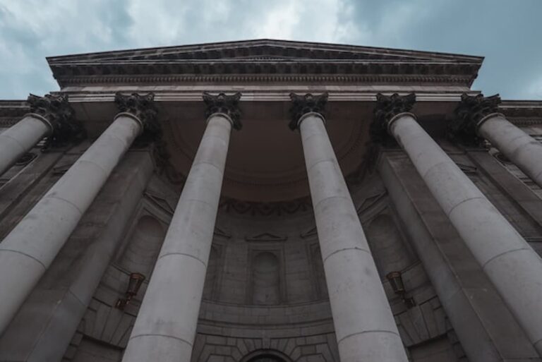 A large stone courthouse with tall columns under a blue sky