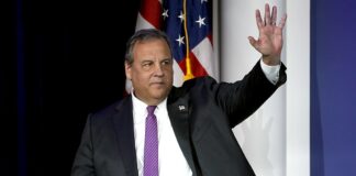 Former New Jersey Governor Chris Christie waves while speaking at a political event in Las Vegas.
