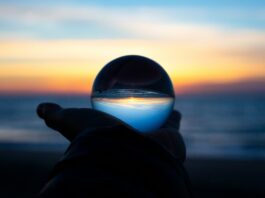 2025 Was the First Year With No New U.S. Sports Betting Laws Since PASPA — What Comes Next in 2026 A hand holding a clear glass ball on a beach at dusk