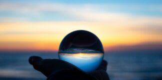 2025 Was the First Year With No New U.S. Sports Betting Laws Since PASPA — What Comes Next in 2026 A hand holding a clear glass ball on a beach at dusk