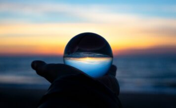 2025 Was the First Year With No New U.S. Sports Betting Laws Since PASPA — What Comes Next in 2026 A hand holding a clear glass ball on a beach at dusk