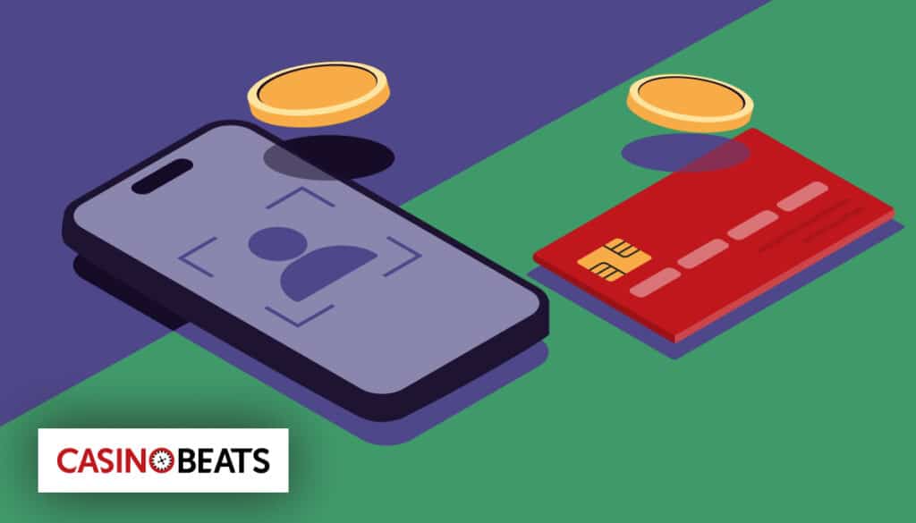 Smartphone using biometric login and a bank card with coins representing open banking payments at online casinos