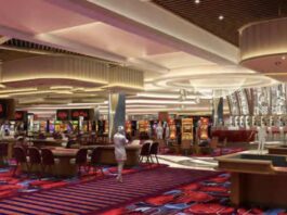 Bally’s Secures $1.1B Financing as New Chicago Casino Renderings Debut, Boosting New York Bid Interior rendering of Bally’s Chicago casino showing table games, slot machines, patterned carpeting, and decorative ceiling lighting across a large open gaming floor.