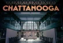 Interior of a Chattanooga train-station style terminal with a large illuminated “CHATTANOOGA” marquee sign above empty seating