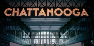 Interior of a Chattanooga train-station style terminal with a large illuminated “CHATTANOOGA” marquee sign above empty seating