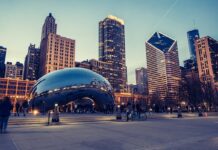 A view of Chicago’s downtown skyline at dusk with the Cloud Gate sculpture in Millennium Park and pedestrians in the foreground.