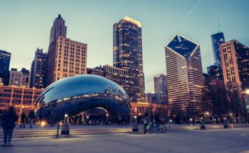 Sports Betting Alliance Warns Chicago Could Force Sportsbooks Offline as City Council Passes Budget A view of Chicago’s downtown skyline at dusk with the Cloud Gate sculpture in Millennium Park and pedestrians in the foreground.