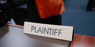 Coinbase Sues Illinois, Michigan, and Connecticut Over Prediction Markets as Legal Fight Expands to 10 States Plaintiff nameplate on a courtroom table.