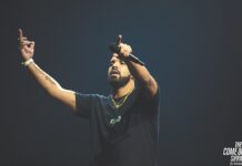Drake performing on stage while holding a microphone