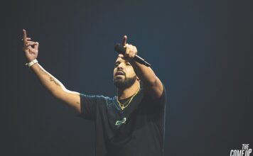 Drake performing on stage while holding a microphone