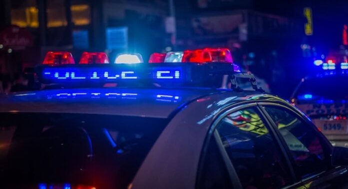 Police vehicle with flashing red and blue lights during a nighttime law enforcement operation