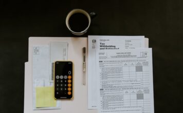 IRS Raises Slot Jackpot Tax Reporting Threshold to $2,000 Ahead of 2026 Calculator, tax forms, envelopes, and paperwork arranged on a desk related to U.S. tax filing