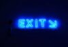 ‘The Pulse’ on Sweepstakes Casinos Amid US Legal Scrutiny & Model Shifts Blue neon “Exit” sign with an arrow pointing right against a dark background