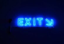 Kentucky Sees Quiet Sweepstakes Casino Exits as 30+ Platforms Pull Back Blue neon “Exit” sign with an arrow pointing right against a dark background