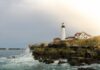 Portland Head Light on a rocky Maine coastline with waves crashing below