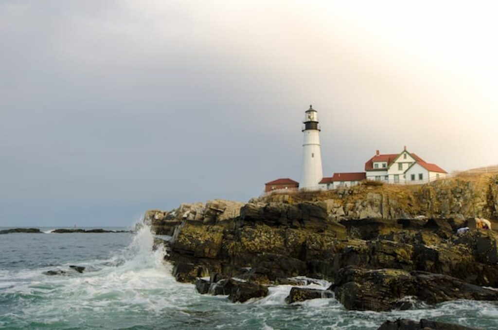 Portland Head Light on a rocky Maine coastline with waves crashing below