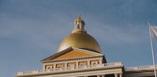 Massachusetts Moves to Require Sportsbooks to Inform Bettors When — and Why — They are Limited The Massachusetts State House in Boston, featuring its gold dome and columned facade under a clear sky