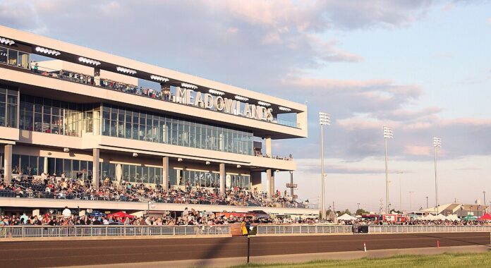 New York’s Casino Expansion Reignites Northern New Jersey's Racino Push Crowds gathered in the grandstand at the Meadowlands Racetrack during a live racing event at sunset.