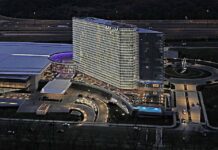 Aerial night view of the MGM National Harbor hotel and casino complex with illuminated tower, entrance, and surrounding roads.