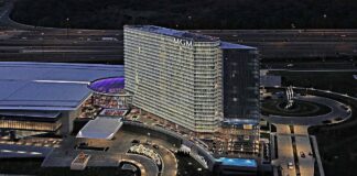 Aerial night view of the MGM National Harbor hotel and casino complex with illuminated tower, entrance, and surrounding roads.