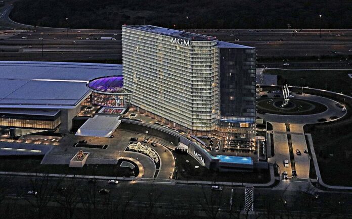 Aerial night view of the MGM National Harbor hotel and casino complex with illuminated tower, entrance, and surrounding roads.