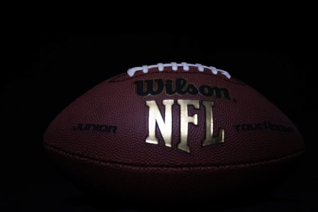 Close-up of an official NFL football on a dark background.