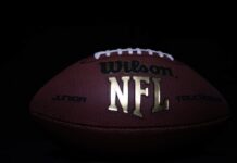 Close-up of an official NFL football on a dark background.