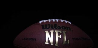 Close-up of an official NFL football on a dark background.