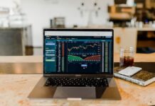 Laptop displaying financial trading charts on a desk