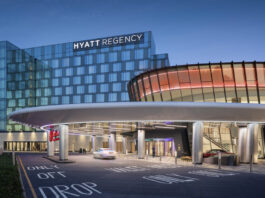 Resorts World Seeks Standardized Tax Rate Across New York Casinos Rendering of the Resorts World New York City at Aqueduct Racetrack, showing the connected Hyatt Regency hotel and main casino entrance at dusk.