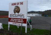 Sign marking land belonging to the Scotts Valley Band of Pomo Indians, with modular buildings in the background