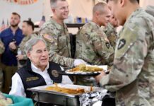 Texas Governor Greg Abbott serving food to uniformed service members during a visit with troops.