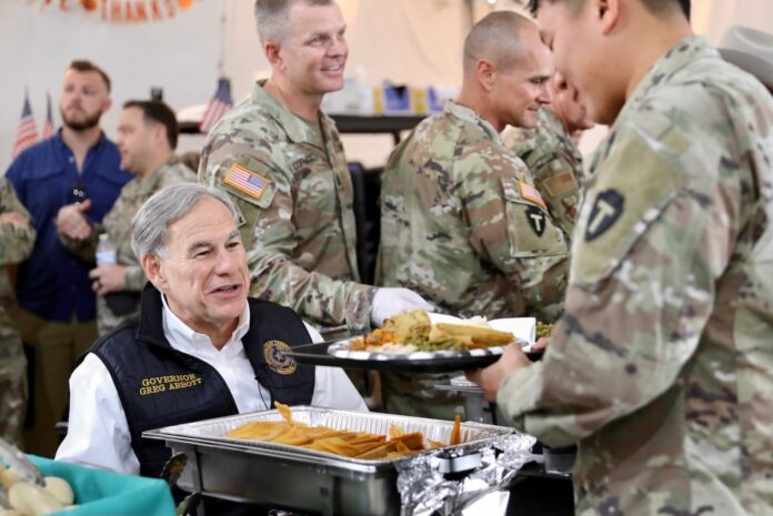 Texas Governor Greg Abbott serving food to uniformed service members during a visit with troops.