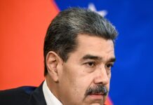 Venezuelan President Nicolás Maduro speaking during a formal meeting, wearing a dark suit and patterned tie.