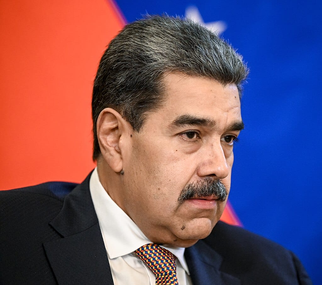 Venezuelan President Nicolás Maduro speaking during a formal meeting, wearing a dark suit and patterned tie.