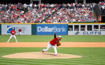 Roosters Defense Raised in Court Filing Challenging MLB Betting Allegations A Cleveland Guardians pitcher delivers a pitch from the mound during a daytime MLB game with a full crowd in the stands.