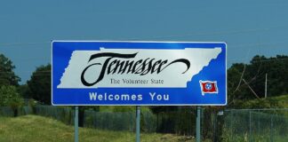 Tennessee welcome sign along a highway reading "Tennessee, The Volunteer State Welcomes You."