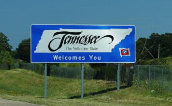 Tennessee welcome sign along a highway reading "Tennessee, The Volunteer State Welcomes You."