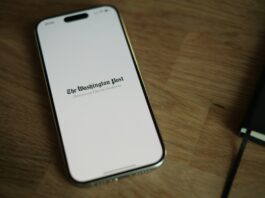Coalition for Prediction Markets Responds to Insider Trading Debate With Full-Page Ad in Washington Post A smartphone displaying The Washington Post logo on a wooden surface