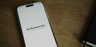 Coalition for Prediction Markets Responds to Insider Trading Debate With Full-Page Ad in Washington Post A smartphone displaying The Washington Post logo on a wooden surface